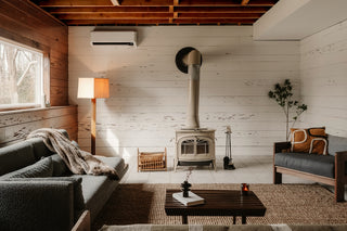 Cozy living room with wood stove and sofa.