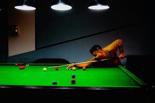 Man playing snooker under bright lights
