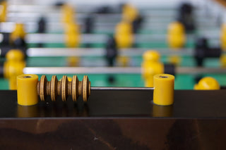 Close-up of a foosball table with yellow players.